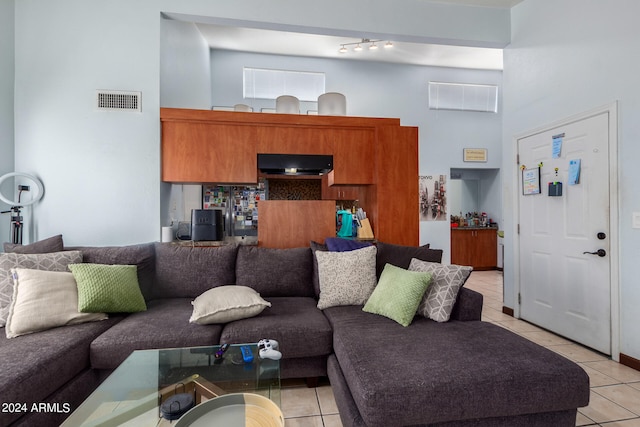 tiled living room with a towering ceiling