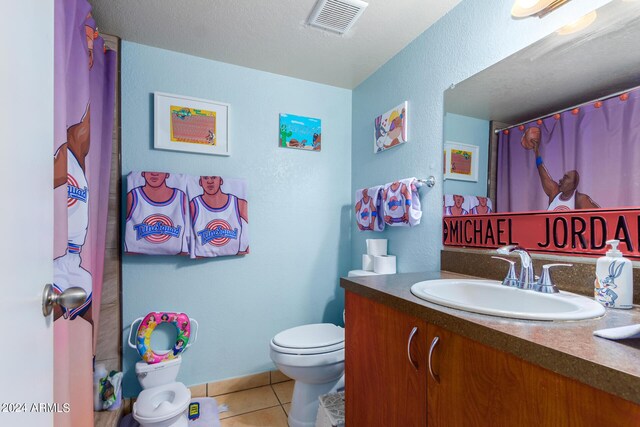 bathroom with a textured ceiling, a shower with shower curtain, tile patterned floors, vanity, and toilet