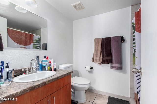 bathroom featuring tile patterned flooring, vanity, and toilet