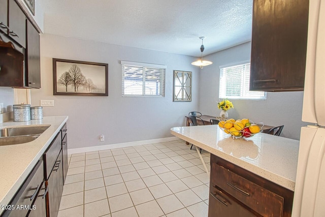 4905 E Horseshoe Ln, Cottonwood, AZ 86326 - kitchen featuring light stone countertops, light tile patterned floors, dark brown cabinets, a sink, and a textured ceiling