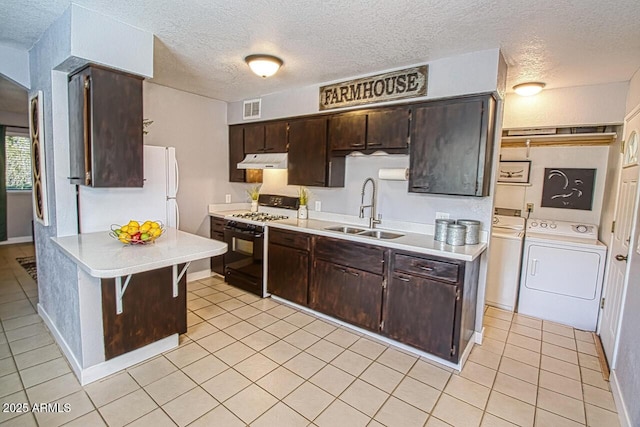 4905 E Horseshoe Ln, Cottonwood, AZ 86326 - kitchen with a sink, under cabinet range hood, washing machine and dryer, light countertops, and gas stove