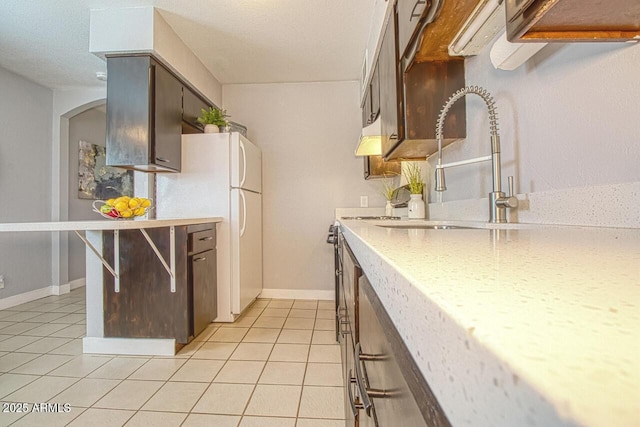 4905 E Horseshoe Ln, Cottonwood, AZ 86326 - kitchen with a sink, light countertops, freestanding refrigerator, arched walkways, and light tile patterned flooring