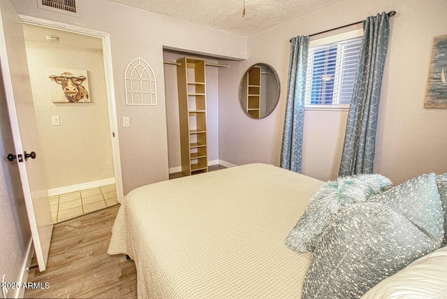 4905 E Horseshoe Ln, Cottonwood, AZ 86326 - bedroom with wood finished floors, a closet, baseboards, visible vents, and a textured ceiling