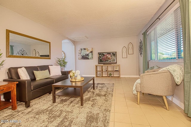 4905 E Horseshoe Ln, Cottonwood, AZ 86326 - living area featuring light tile patterned flooring, a textured ceiling, arched walkways, and baseboards