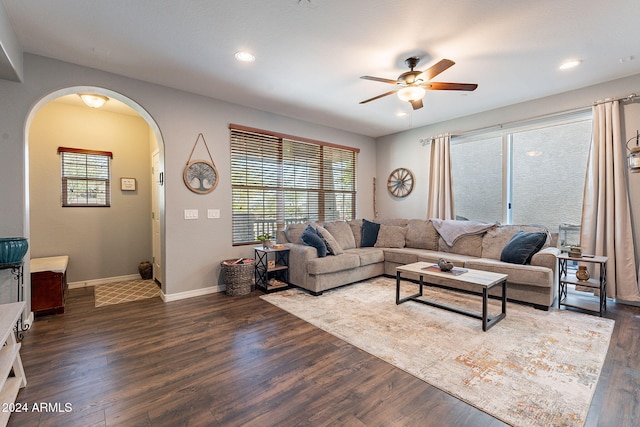 living room featuring ceiling fan and dark hardwood / wood-style floors