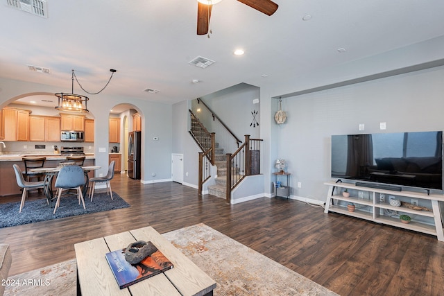 living room featuring ceiling fan with notable chandelier, dark hardwood / wood-style floors, and sink