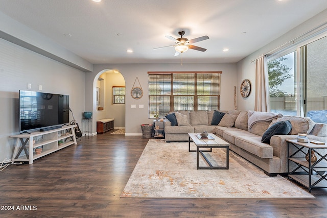 living room with ceiling fan, plenty of natural light, and dark wood-type flooring