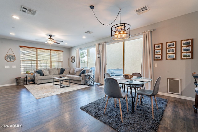 dining space featuring dark wood-type flooring and ceiling fan with notable chandelier