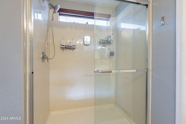 bathroom with a shower with door