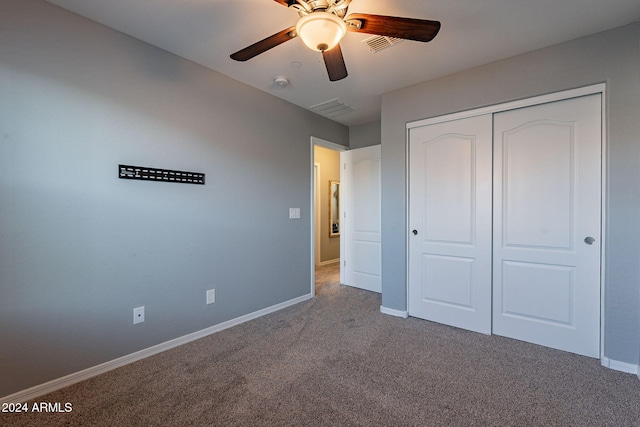 unfurnished bedroom with ceiling fan, carpet floors, and a closet