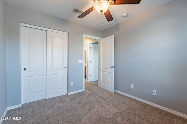 unfurnished bedroom featuring ceiling fan, a closet, and carpet