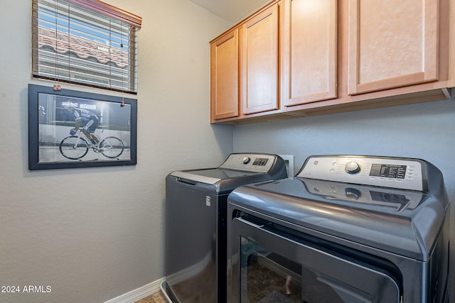 laundry area featuring washer and dryer and cabinets