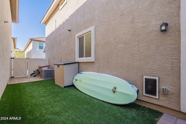 exterior space with a lawn and central AC