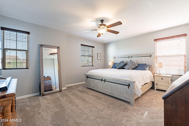 carpeted bedroom with multiple windows and ceiling fan