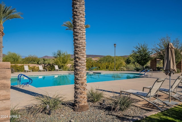 view of swimming pool with a mountain view and a patio