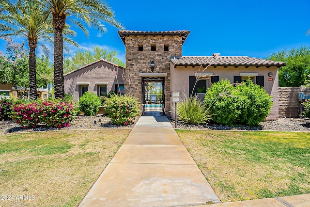 mediterranean / spanish house featuring a front lawn