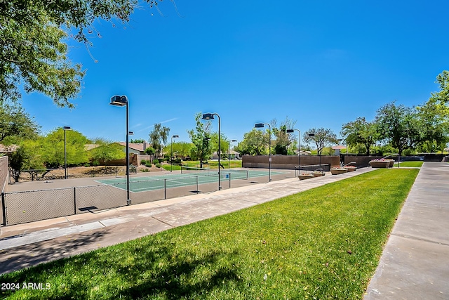 view of sport court with tennis court and a lawn