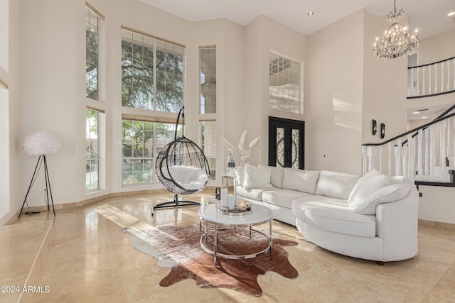 living room featuring a notable chandelier and a towering ceiling