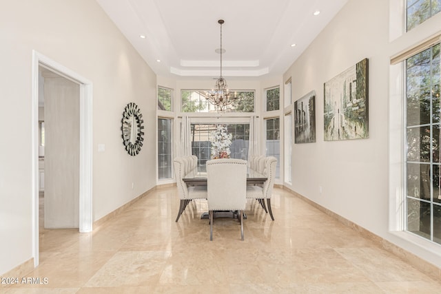 dining space featuring a high ceiling, a chandelier, and plenty of natural light