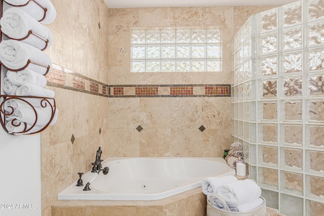 bathroom featuring tiled bath and tile walls