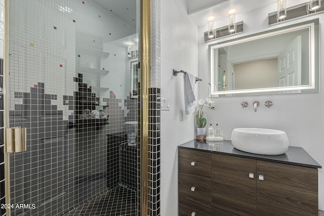 bathroom featuring a shower with door and vanity