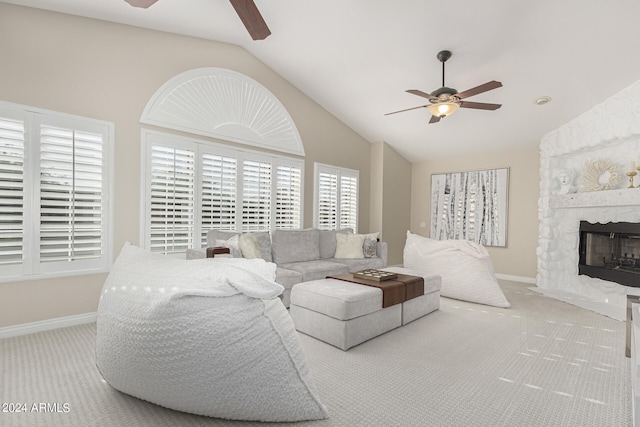 carpeted living room with ceiling fan, a fireplace, lofted ceiling, and a wealth of natural light