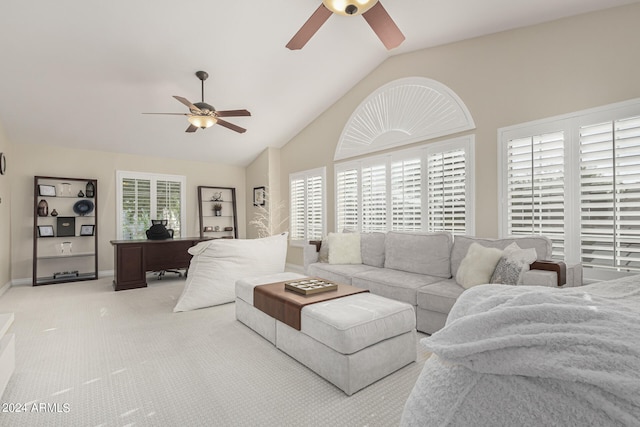 living room with high vaulted ceiling, ceiling fan, light colored carpet, and a healthy amount of sunlight