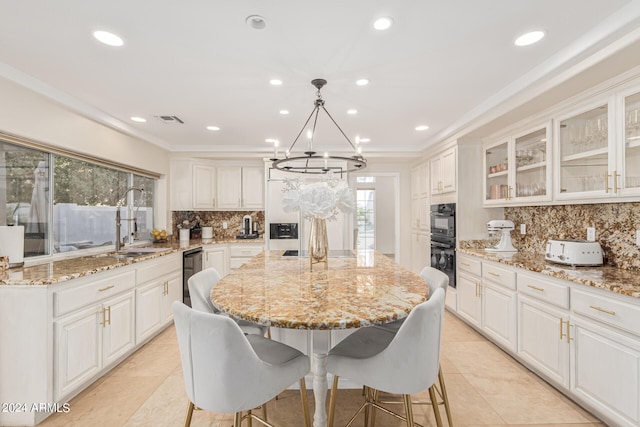 kitchen featuring a notable chandelier, white cabinetry, a center island, and a healthy amount of sunlight