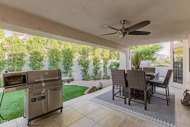 view of patio / terrace with ceiling fan and a grill