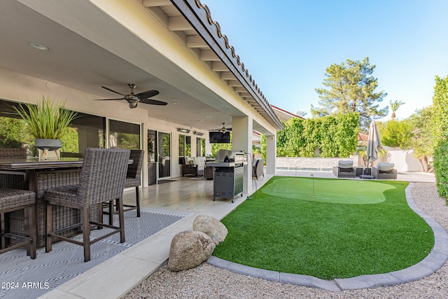 view of yard with a patio, area for grilling, ceiling fan, and an outdoor hangout area