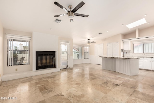 15602 N 19th St, Phoenix, AZ 85022 - unfurnished living room featuring vaulted ceiling with skylight, plenty of natural light, and ceiling fan