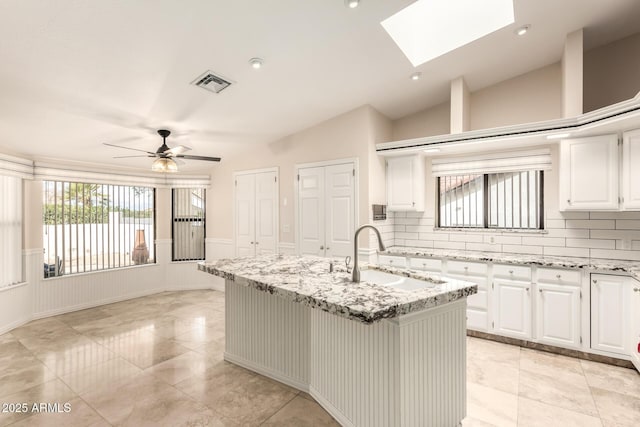15602 N 19th St, Phoenix, AZ 85022 - kitchen with sink, an island with sink, white cabinets, and light stone counters