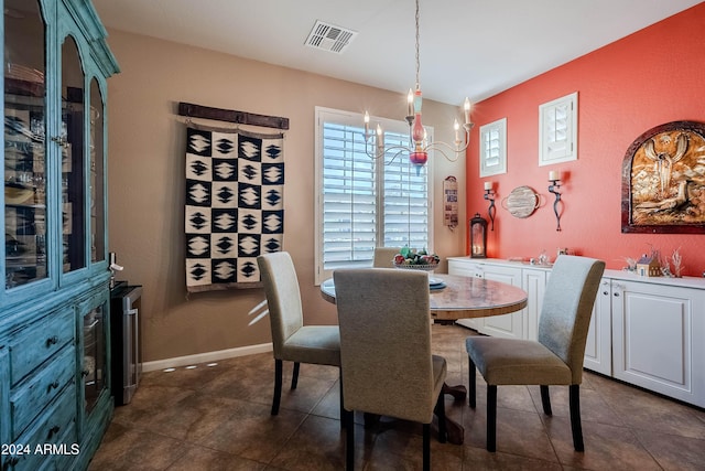 dining room with dark tile patterned floors and an inviting chandelier