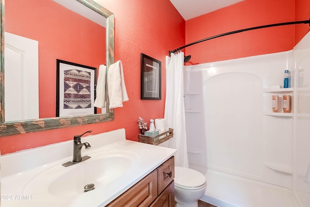 bathroom with walk in shower, vanity, and toilet