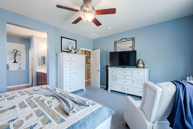 bedroom with light carpet, connected bathroom, and ceiling fan