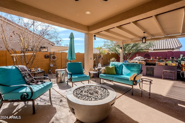 view of patio featuring ceiling fan and an outdoor living space with a fire pit