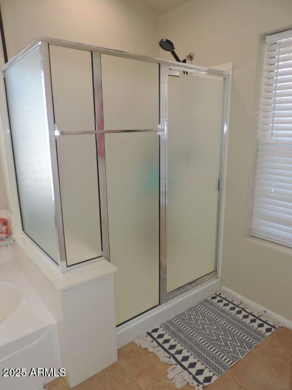 full bathroom with a bath, a shower stall, and tile patterned flooring