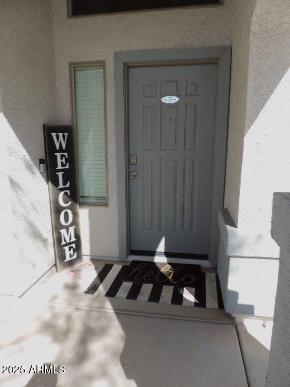 doorway to property featuring stucco siding