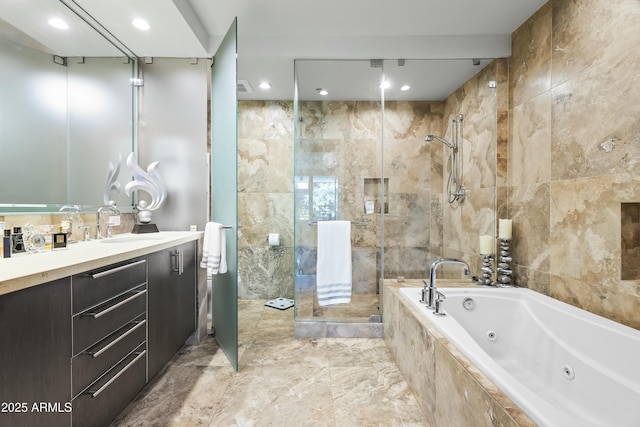 bathroom with vanity, tile walls, a jetted tub, and a stall shower