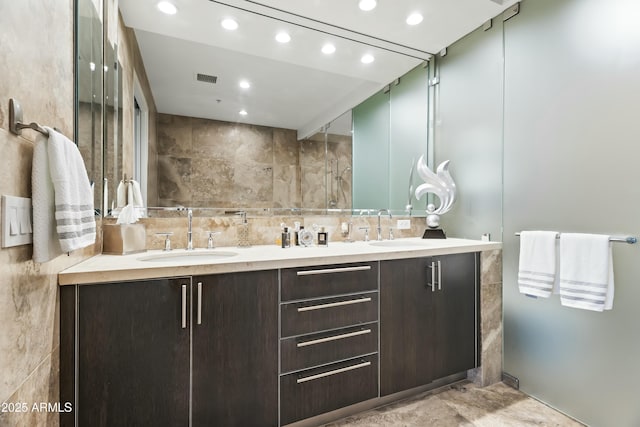 bathroom featuring recessed lighting, a sink, decorative backsplash, and double vanity