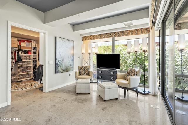 sitting room with baseboards, a healthy amount of sunlight, and visible vents