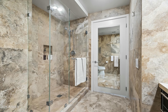 full bath featuring vanity, toilet, tile walls, and a stall shower