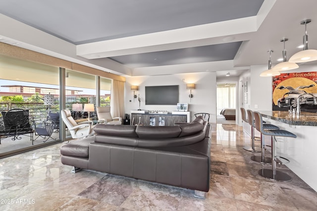 living area featuring a raised ceiling, marble finish floor, and visible vents