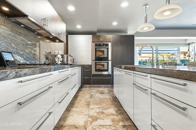 kitchen featuring a sink, stainless steel appliances, backsplash, pendant lighting, and modern cabinets