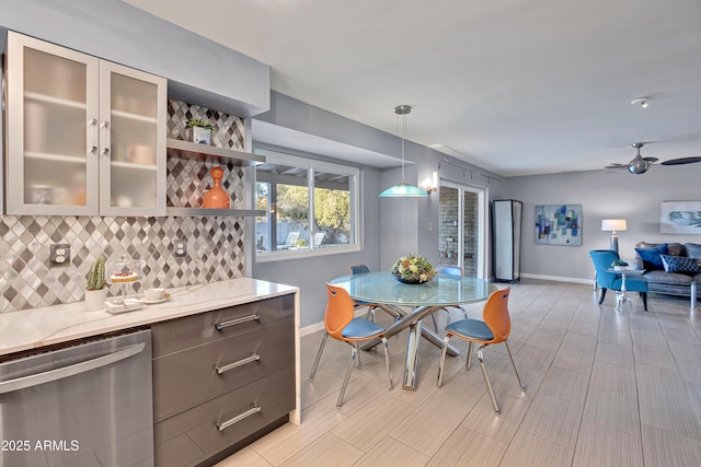 kitchen featuring ceiling fan, dishwasher, decorative backsplash, hanging light fixtures, and light stone counters