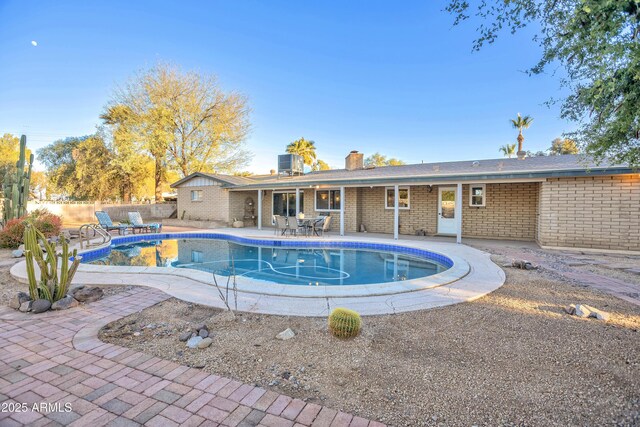 view of swimming pool featuring a patio area and central air condition unit