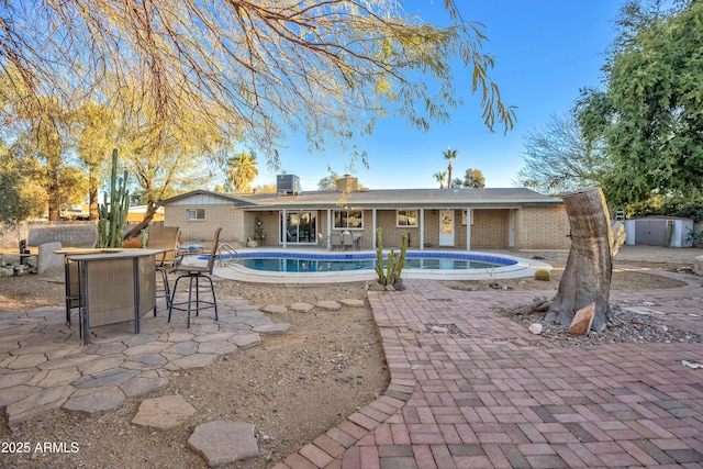 view of swimming pool with an outdoor bar and a patio