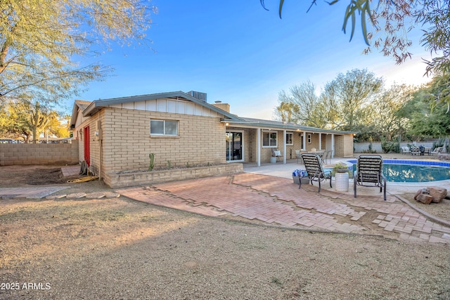 back of house featuring a fenced in pool and a patio