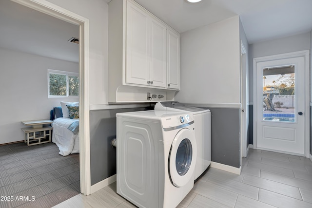 laundry room with independent washer and dryer and cabinets