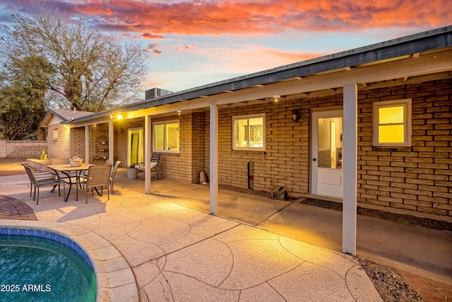 back house at dusk featuring a patio area